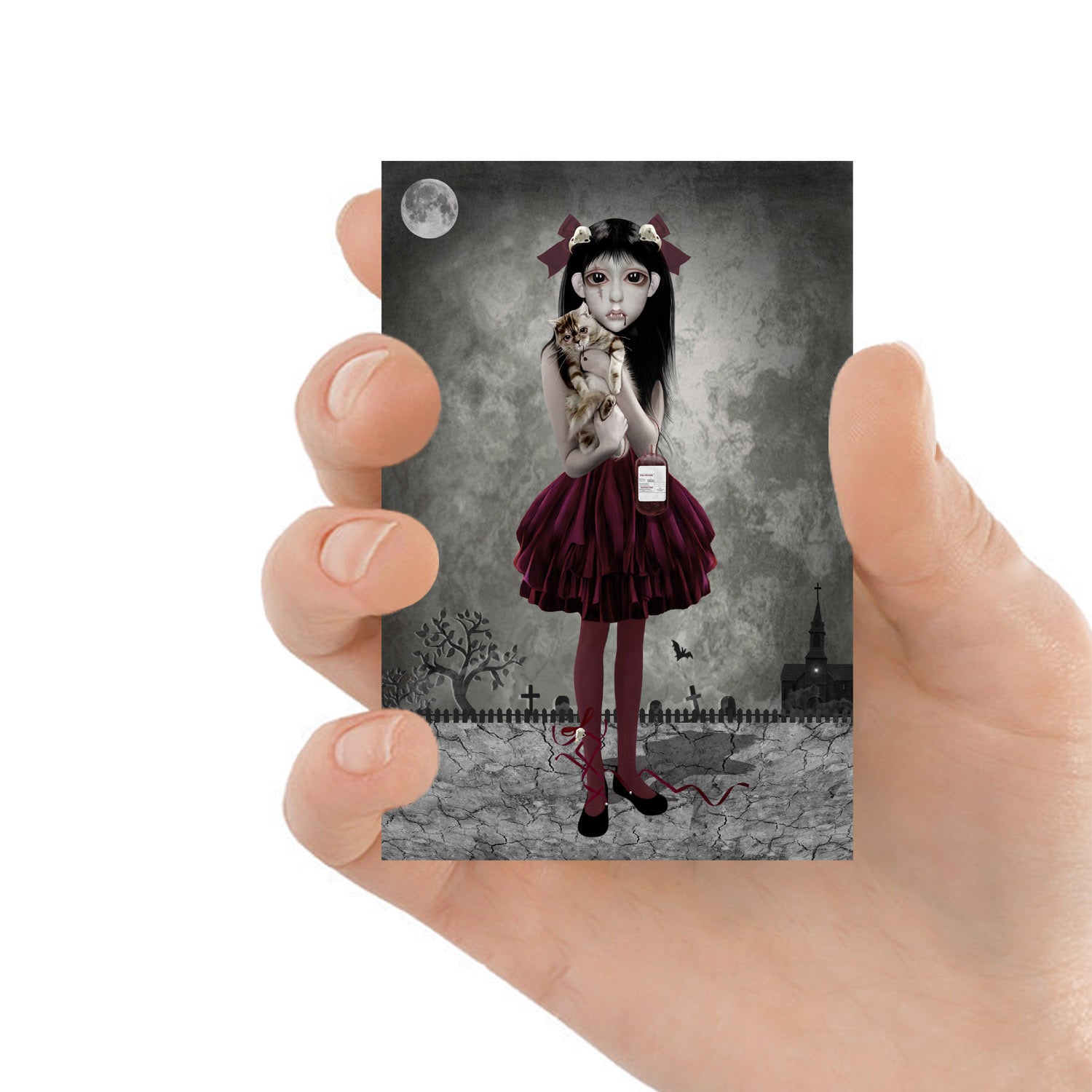 ACEO art card featuring a vampire girl with cat, held in hand to showcase the miniature size and creepy cute design.