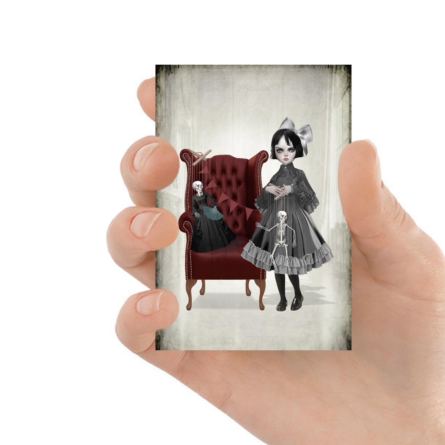 ACEO art card featuring a victorian girl and skeleton marionette dolls, held in hand—creepy cute gothic art style with dark, whimsical elements.