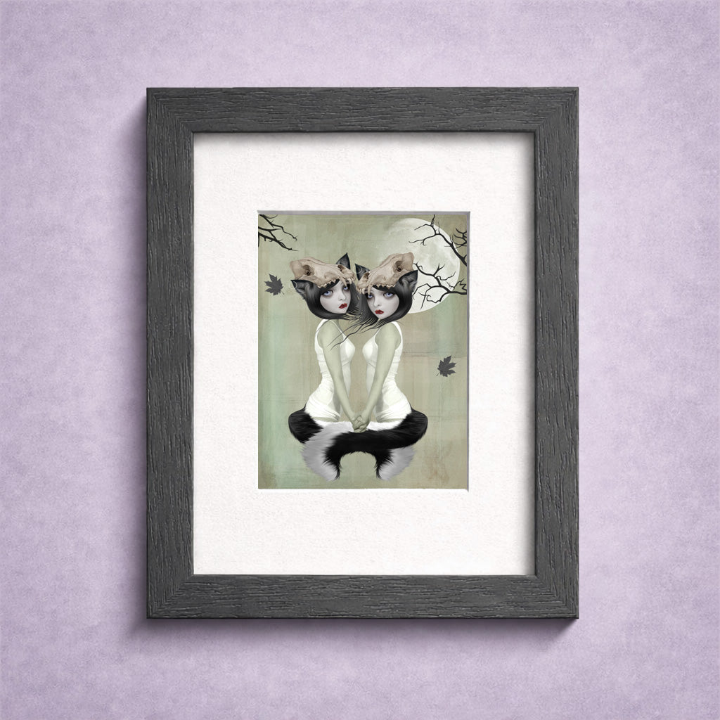 Framed ACEO artwork of two werewolf sisters sitting together beneath the moon on a light background.