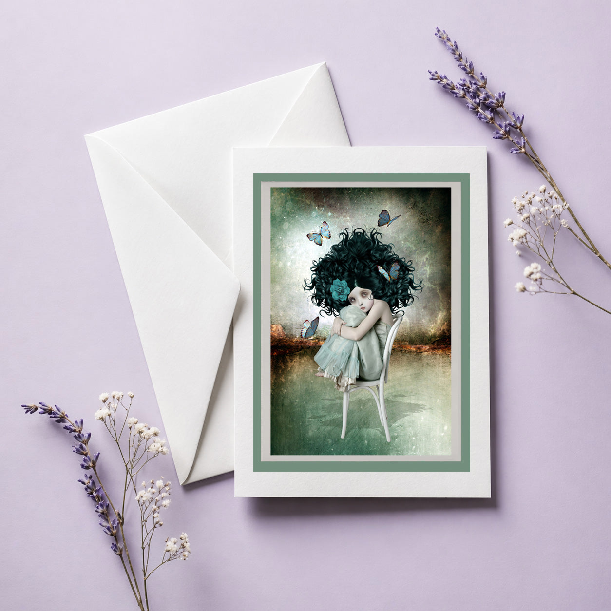 Greeting card with a girl with dark hair and butterflies, envelope, and dried flowers on a purple background