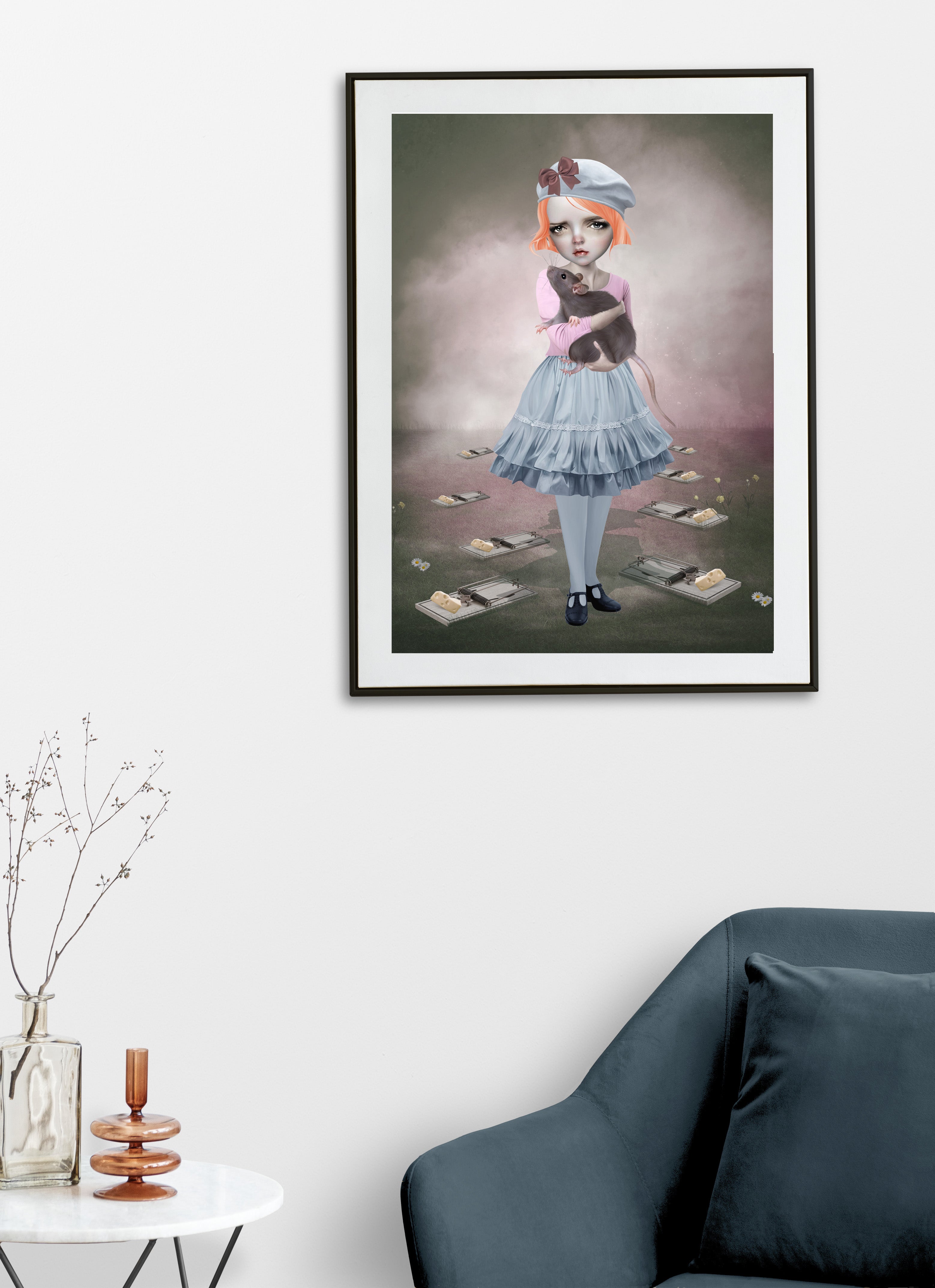 Framed artwork of a quirky girl holding an oversized rat keeping him safe from the mousetraps surrounding them. Hung on a wall above a sofa display.