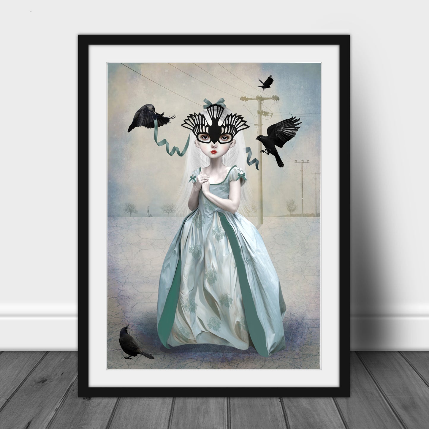 Whimsical bird art print in black frame featuring a girl in a blue gown adorned with a blackbird mask surrounded by blackbirds. 