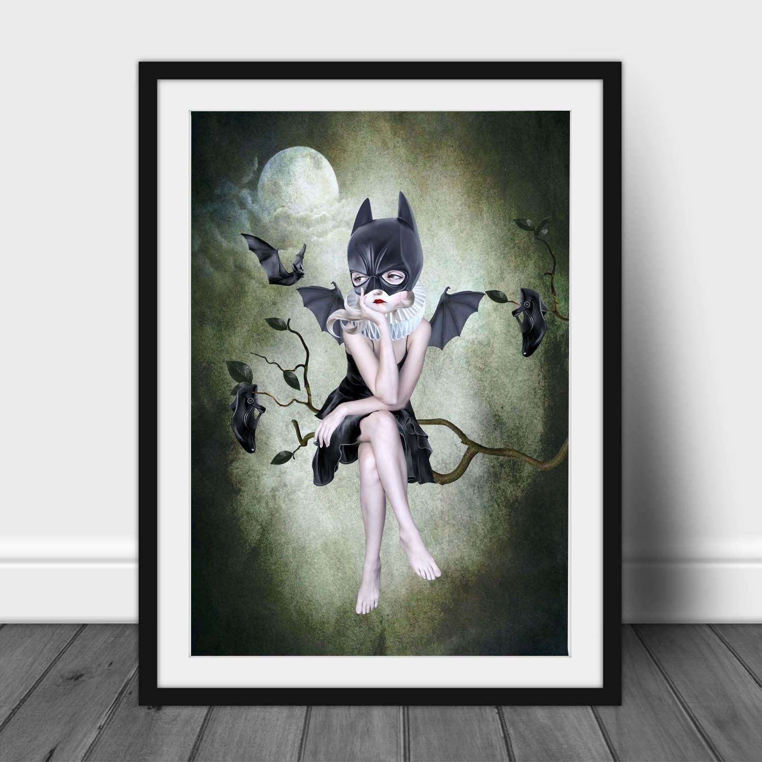 This framed whimsigoth print features a girl in a bat mask, perched on a branch under the moonlight, surrounded by flying bats.
