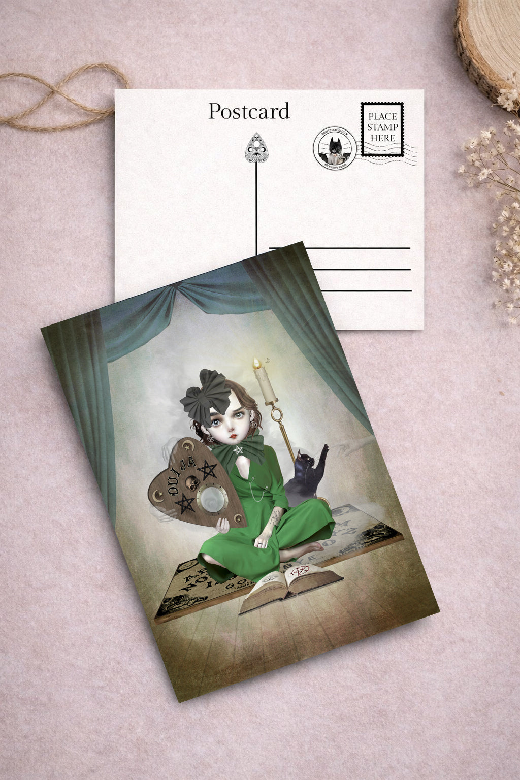 illustrated postcard of a girl and her cat performing a seance on an oversized ouija board.