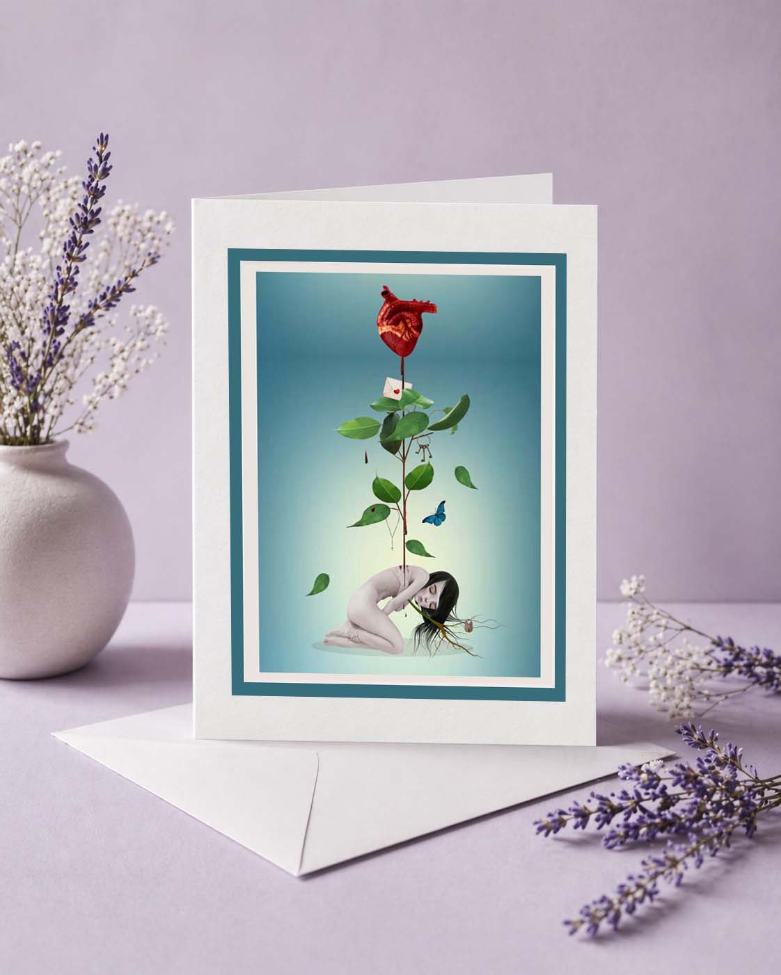 A blank sad romance greeting card standing upright in front of its white envelope, showcased on a tabletop next to a white ceramic vase with lavender and baby's breath.